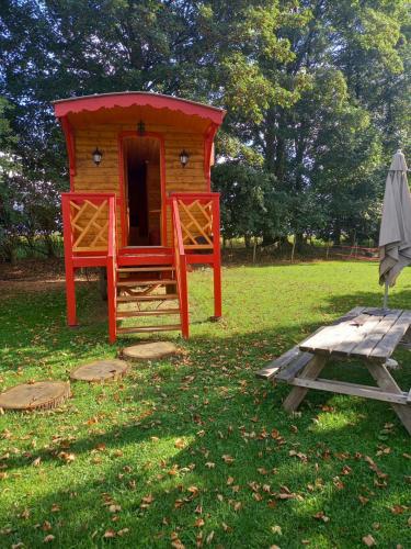 Grainville-YmauvilleLes Insolites de Nini的一个带野餐桌和遮阳伞的红色游乐室