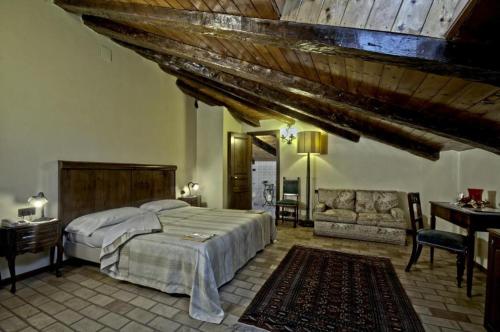 阿尔托蒙泰Castello di Altomonte的一间卧室配有一张床、一张桌子和一张沙发