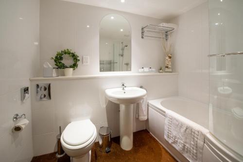 SedgefordThe King William IV Country Inn & Restaurant的白色的浴室设有水槽、卫生间和浴缸。