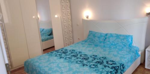 斯科普里Lovely condo next to salt room, bus station的一间卧室配有蓝色的床和镜子