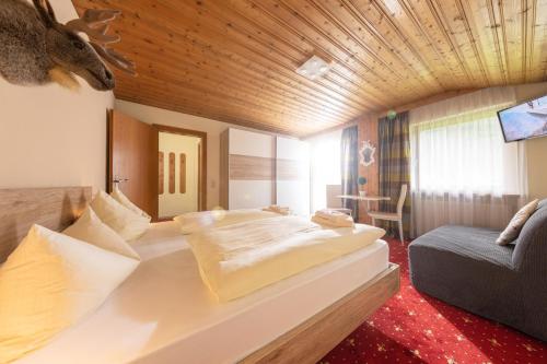 瓦尔德阿尔贝格T3 Gasthof Spullersee的酒店客房设有一张大床和一张沙发。