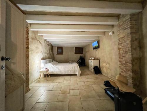 卡利亚里Castello Room & Spa的卧室配有白色的床和石墙