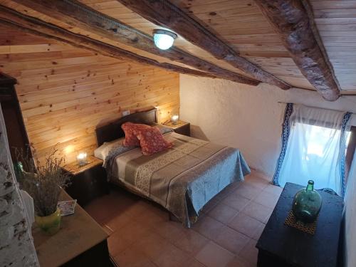 BelCasa Leonor的卧室配有一张床铺,位于带木墙的房间内