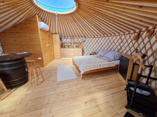 拉茨凯韦Jurtafarm Ráckeve - a nomád luxus的蒙古包内一间卧室,配有一张床和一张桌子