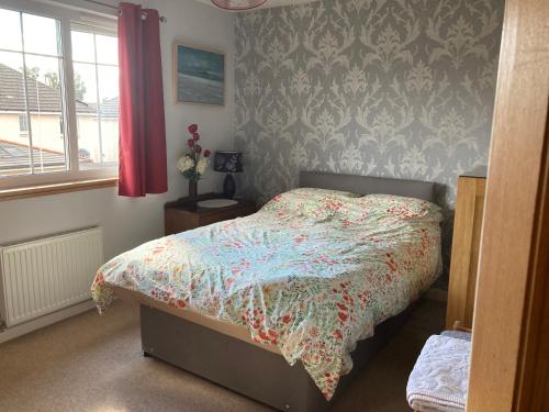罗塞斯Caledonia House的一间卧室配有一张带花卉棉被的床