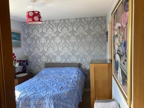 罗塞斯Caledonia House的一间卧室设有蓝色的床和墙壁