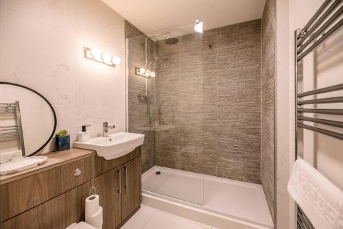 贝里圣埃德蒙兹Guildhall Street Apartment的浴室配有盥洗盆、浴缸和镜子