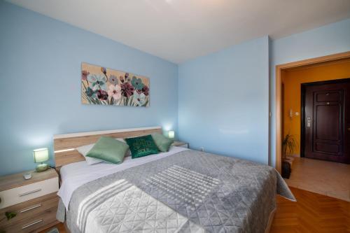 奥西耶克Apartman Silvija的卧室配有一张床,墙上挂有绘画作品