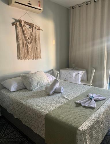 布卢梅瑙Suíte Aconchego的一间卧室配有带毛巾的床