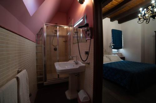 尼科洛西多拉塔别墅酒店的一间带水槽和淋浴的浴室以及一张床