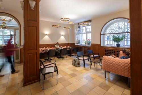 弗莱堡密涅瓦酒店的一间餐厅,人们坐在房间里桌子旁