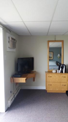 蒙特贝罗Motel Shantik的客房设有电视和带镜子的书桌