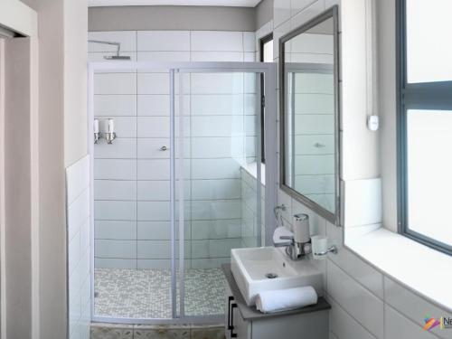比勒陀利亚Next To Apartment Hotel的带淋浴、盥洗盆和镜子的浴室