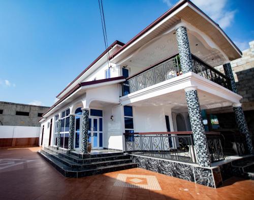 OteleAduk Guest House Airport City Accra的白色房子的一侧设有阳台