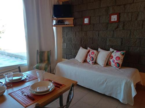 多拉达斯海滩Aquamarinas Departamentos的酒店客房配有一张床、一张桌子和一张桌子。