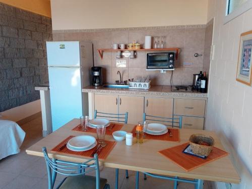 多拉达斯海滩Aquamarinas Departamentos的一间带桌子和冰箱的小厨房