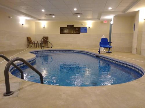 布拉特尔伯勒Comfort Inn & Suites Brattleboro I-91的一个带蓝色椅子的房间的大型游泳池