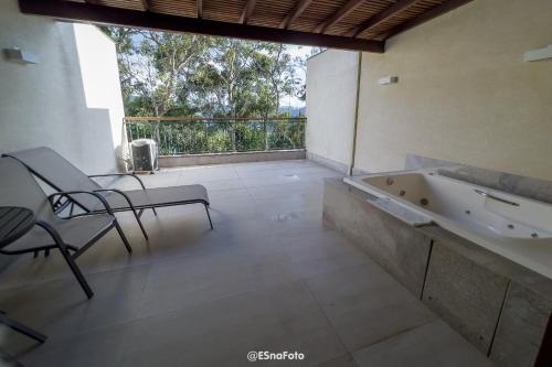 佩德拉阿祖尔Vista Azul Hotel的带浴缸和桌椅的浴室