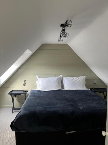沃明斯特Luxury stay Kings Annexe 5 minutes from Longleat的一间卧室配有一张带两张桌子的黑色床