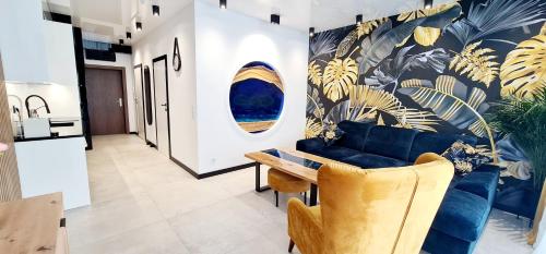 博茨科沃Apartamenty Aquarius Gold Boszkowo的客厅配有蓝色的沙发和桌子