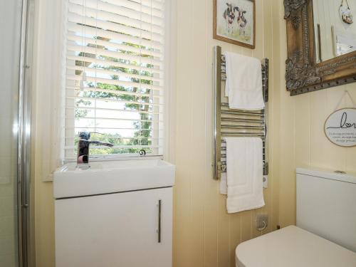 克雷迪顿Orchard Retreat的一间带水槽和卫生间的浴室以及窗户。