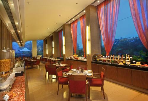 艾哈迈达巴德Fortune Select SG Highway, Ahmedabad - Member ITC's Hotel Group的一间带桌椅的餐厅以及一间自助餐