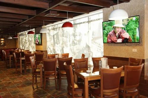 Umm Uthainah7 Days Hotel的用餐室配有桌椅和平面电视。