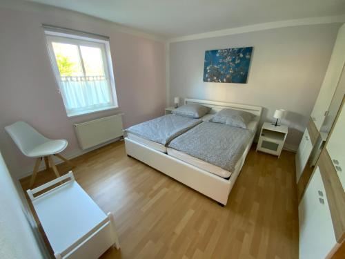 新勃兰登堡große Wohnung zentral gelegen的一间卧室配有一张床和一把椅子