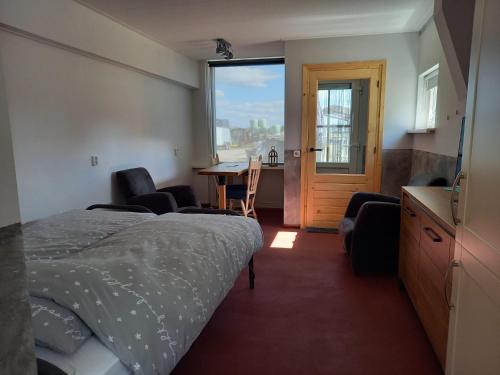 Stuifzand斯塔尔扎特沙普公寓酒店的一间卧室配有一张床、一张桌子和一个窗户。