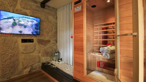 阿尔库什迪瓦尔德维什Love Story - Lareira, Sauna & Piscina的一间墙上配有电视的桑拿浴室和一间客房