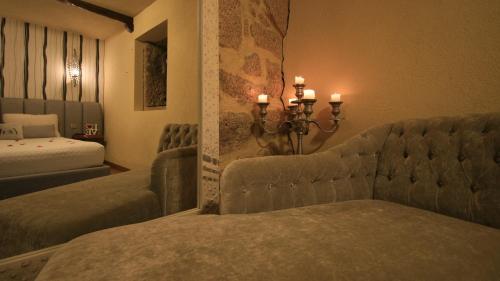 阿尔库什迪瓦尔德维什Love Story - Lareira, Sauna & Piscina的一间卧室设有两张床、一张沙发和蜡烛