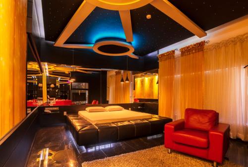 南卡希亚斯Gran Motel Dubai的一间卧室配有一张床和一张红色椅子