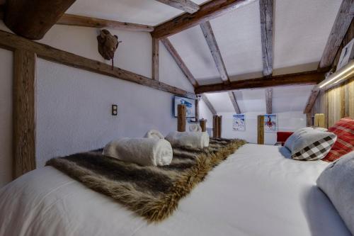 瓦勒迪泽尔Appartement esprit chalet - splendide vue montagne的一张大床,位于一个房间,配有一张白色的大床和毛皮