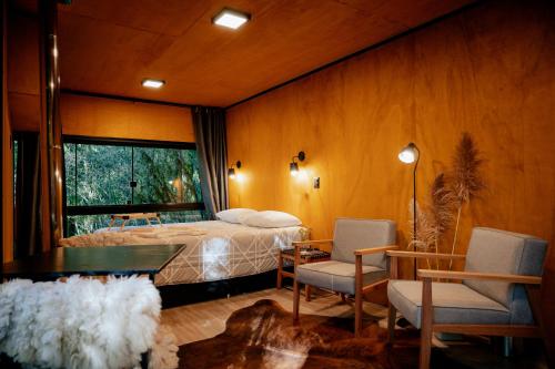 圣弗朗西斯科-迪保拉Reserva Alpes的卧室配有一张床和一张桌子及椅子