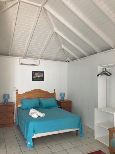 英吉利港安提瓜洛奇公寓的一间卧室设有蓝色的床和白色的墙壁