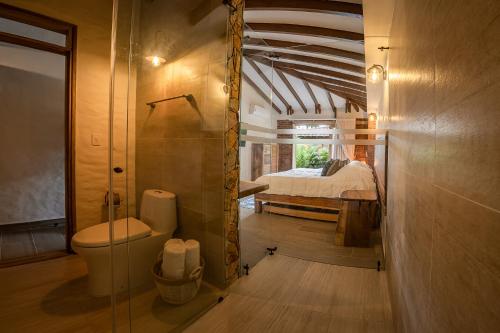 佩雷拉PETRA SANTA HOTEL BOUTIQUE的一间带卫生间的浴室和一张位于客房内的床。