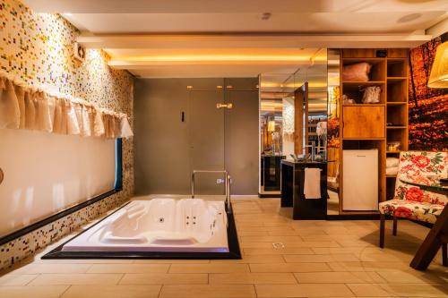 南卡希亚斯Gran Motel Dubai的带沙发的客房内的大浴缸