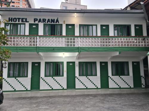 巴拉奈里奥-坎布里乌Hotel Paraná BC的绿门和阳台的酒店