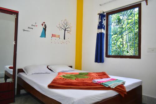 Mādāri HātJaldapara Binaychapa homestay的一间卧室配有一张带窗户和毯子的床