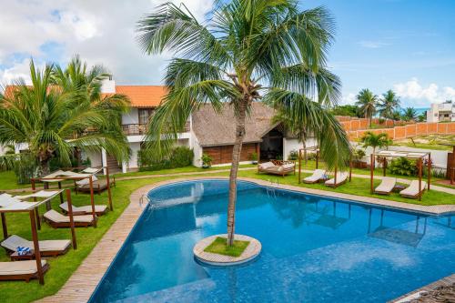 卡莫辛Villa Zen Hotel的一个带棕榈树和椅子的游泳池