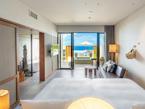 今归仁村One Suite THE GRAND的酒店客房设有一张床,享有海景。