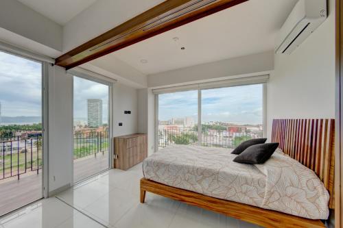 巴亚尔塔港¡Hermoso Condo con espectacular vista a la bahia!!的一间卧室设有一张床和大窗户
