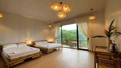 Yen BaiOMTARA RETREAT的一间带两张床的卧室和一个阳台