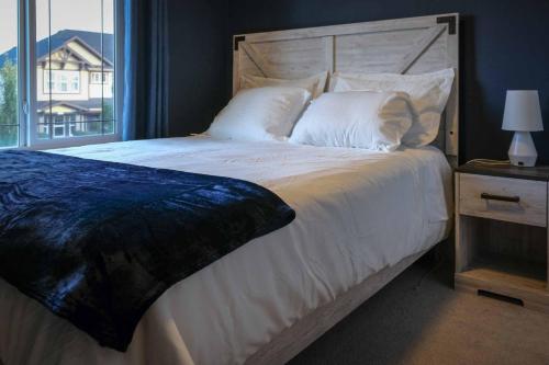 科克伦Entire Home Near Calgary, Canmore & Banff Rocky Mountain Gateway的卧室配有一张大白色床和窗户