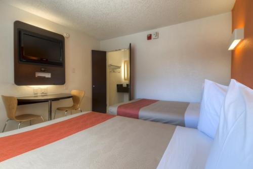 拉斯维加斯拉斯维加斯纯果乐6号汽车旅馆 的一间酒店客房,设有两张床、一张桌子和一台电视机