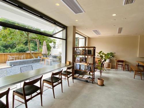 杭州杭州三宿酒店的客厅配有桌椅和大窗户