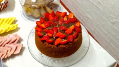 伊利亚贝拉Pousada Canto da Mata Ilhabela的桌上的一块带草莓的巧克力蛋糕