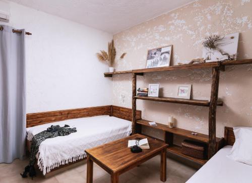卡米拉日OVGORA - Ismini Sea View Room in Kamilari Village的一间卧室设有两张床、一张桌子和一个架子。