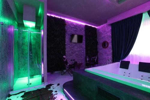 埃博利Alcova Suite&Relax的紫色绿色浴室设有浴缸和淋浴