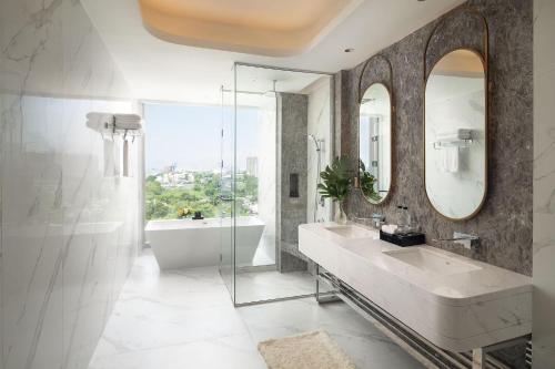 曼谷Asawin Grand Convention Hotel的一间带水槽、浴缸和镜子的浴室
